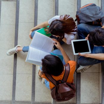 Students university asian together reading book study smiling with tablet at high school campus,college in summer sitting ladder top view.